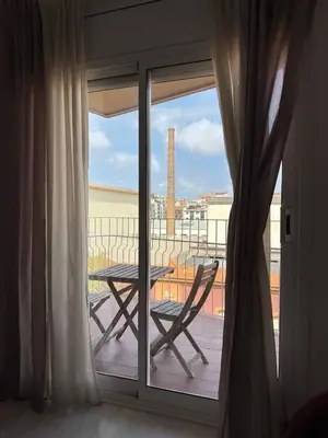 a balcony with a table and a chair on a balcony at City Center 3 Bedroom Apartment! in Barcelona