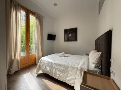 a bedroom with a bed and a window at Centric 2 Bedroom Apartment in Barcelona