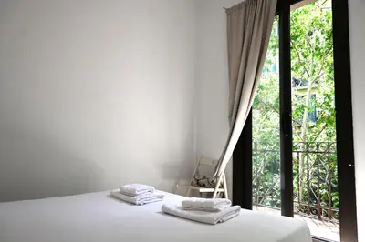 a bedroom with a bed and a large window at Homenfun Barcelona Sants Estación in Barcelona