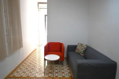 a living room with a blue couch and a red chair at Homenfun Barcelona Sants Estación in Barcelona