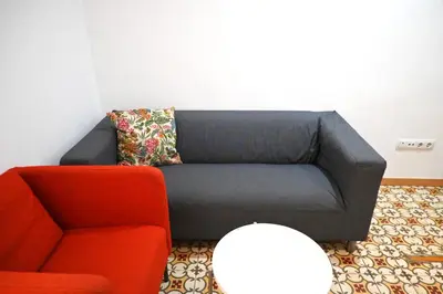 a couch and a chair in a living room at Homenfun Barcelona Sants Estación in Barcelona