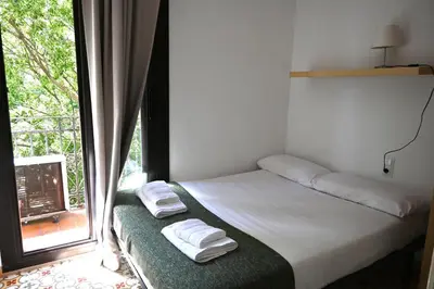 a bed in a room with a window with towels at Homenfun Barcelona Sants Estación in Barcelona