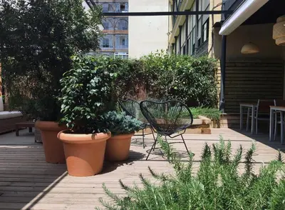a bench sitting on a patio with potted plants at Hotel Àmbit Barcelona in Barcelona
