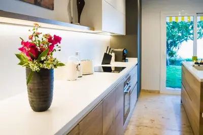 a kitchen with a vase with flowers on the counter at Exclusive Mediterranean Panorama in Sant Pol de Mar in San Pol de Mar