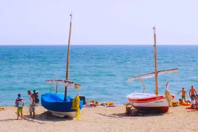 a group of people on a beach with two boats at Exclusive Mediterranean Panorama in Sant Pol de Mar in San Pol de Mar