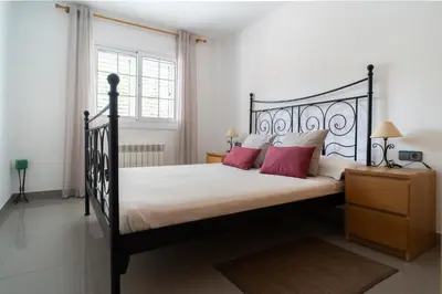 a bedroom with a black bed with red pillows at Bellavista in Argentona