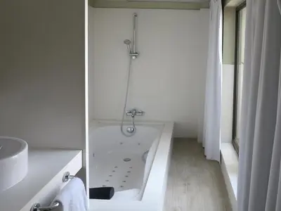 a white bathroom with a tub and a sink at Serennia Exclusive Rooms in Barcelona