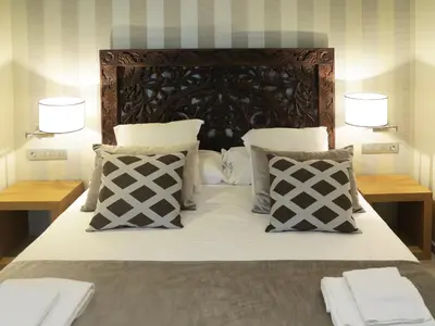 a bedroom with a bed with two lamps and pillows at Serennia Exclusive Rooms in Barcelona