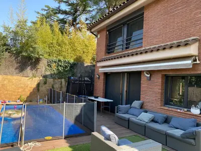a patio with a couch and a swimming pool at Apartamento 3 habitaciones con piscina in Sant Cugat del Vallès