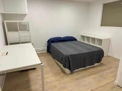 a bedroom with a bed and two white tables at Apartamento 3 habitaciones con piscina in Sant Cugat del Vallès