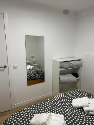 a bedroom with a bed with a mirror and towels at Apartamento 3 habitaciones con piscina in Sant Cugat del Vallès