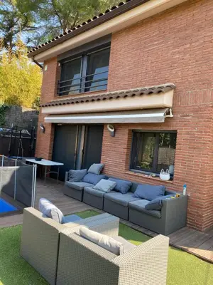 a brick house with a couch in the yard at Apartamento 3 habitaciones con piscina in Sant Cugat del Vallès
