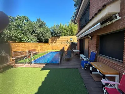 a backyard with a pool and a table and chairs at Apartamento con Piscina en sant Cugat del valles in Sant Cugat del Vallès