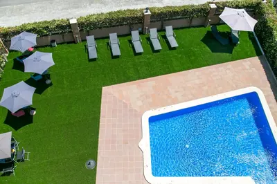 an overhead view of a swimming pool with umbrellas and chairs at Aparthotel Bardon in Castelldefels