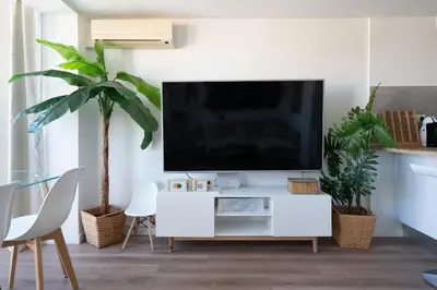 a living room with a tv on a white entertainment center at Castelldefels - Apartment - Sleeps 4 - Beach Side in Castelldefels