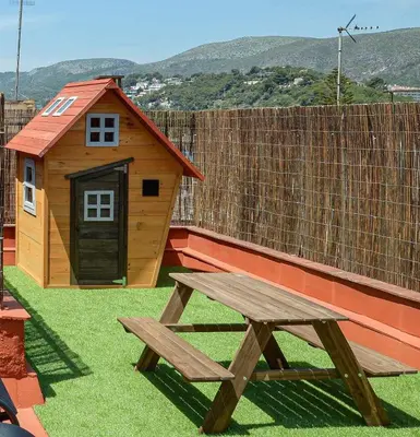 a wooden picnic table and a small dog house at Castelldefels - Apartment - Sleeps 4 - Beach Side in Castelldefels