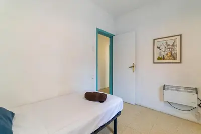 a white room with a bed and an open door at 1º Apartamento 3 hab 15' Barcelona centro 8' Playa in Sant Adria de Besos