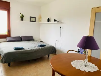 a bedroom with a bed and a table with a lamp at CAN FENICIA - 30 min to F1 & MotoGP - Intimate Villa, Private Pool & Sea View in Arenys de Munt