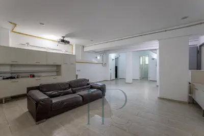 a living room with a brown couch and a kitchen at Gavamar in Gavà