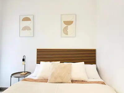 a bedroom with a bed and two pictures on the wall at Atico frente al mar! in Gavà