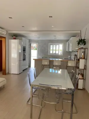 a kitchen with a table and chairs in a room at House 50meters from the beach in Cunit