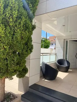 two black wicker chairs sitting on the side of a building at House 50meters from the beach in Cunit