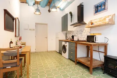 a kitchen with a table and a stove top oven at Estudios a 10' caminando de la playa y a 20' de Barcelona Centro in Sant Adria de Besos