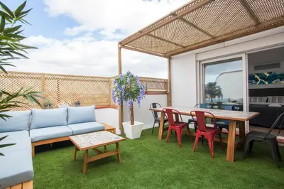 a patio with a couch and a table and chairs at Tendency Apartments 12 Penthouse in Barcelona