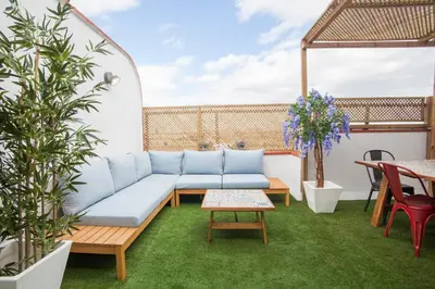 a patio with a couch and a table and chairs at Tendency Apartments 12 Penthouse in Barcelona