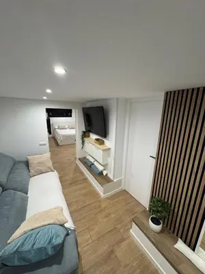 a living room with a couch and a tv at Apartamento a 5 minutos de Sitges in Sant Pere de Ribes