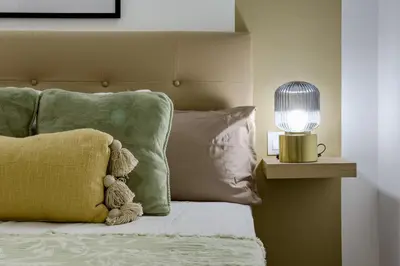 a stuffed teddy bear sitting on a bed with a lamp at Bonito Apartamento en Ronda Sant Pau in Barcelona