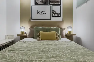 a bedroom with a bed with a green bedspread at Bonito Apartamento en Ronda Sant Pau in Barcelona
