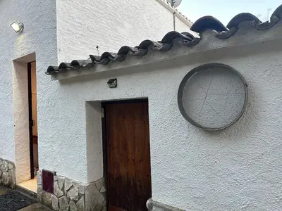 a white building with a wooden door and a mirror at Vallromanes House of Peace and Rest in Vallromanas