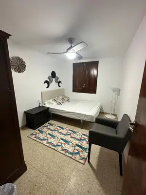 a bedroom with a bed and a chair and a rug at Vallromanes House of Peace and Rest in Vallromanas