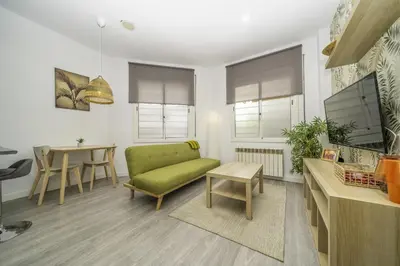 a living room with a green couch and a table at HomeHolidaysRentals Balmes - Costa Barcelona in Calella