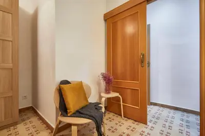 a chair with a blanket sitting next to a door at BBarcelona Perill Flat in Barcelona