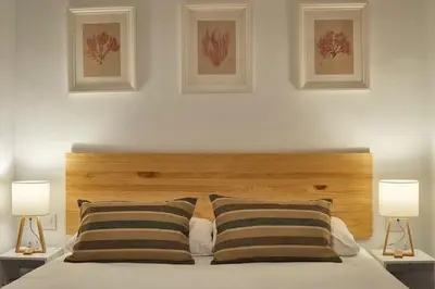 a bedroom with a wooden headboard and two lamps at BBarcelona Perill Flat in Barcelona