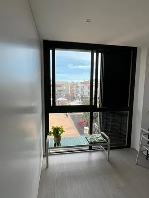 a room with a large window with a view of a building at Artistic beach apartment in Cunit