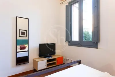 a bedroom with a tv and a mirror at Elegant and cozy retreat in Barcelona