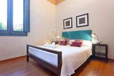 a bedroom with a bed with a green headboard at Elegant and cozy retreat in Barcelona