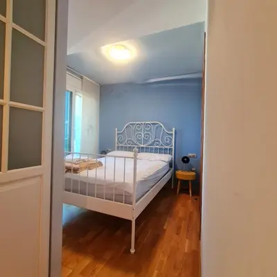 a bedroom with a white bed in a blue room at Alojamiento luminoso y bien ubicado en Terrassa Barcelona in Terrassa