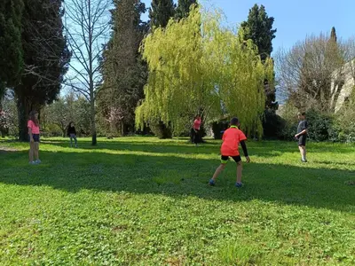 a group of people playing frisbee in a park at El Freixe de l'Ylla in Els Hostalets