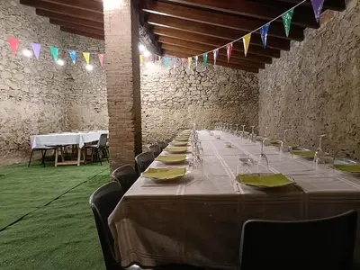 a long table in a room with chairs and flags at El Freixe de l'Ylla in Els Hostalets