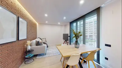 a dining room with a table and chairs and a brick wall at Joan Austria 2 Bedroom Apartment in Barcelona