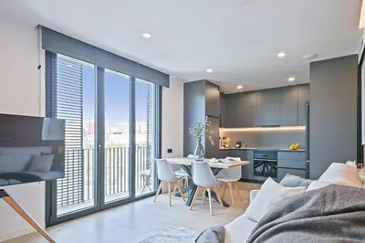 a living room with a couch and a table with chairs at Joan Austria 2 Bedroom Apartment in Barcelona