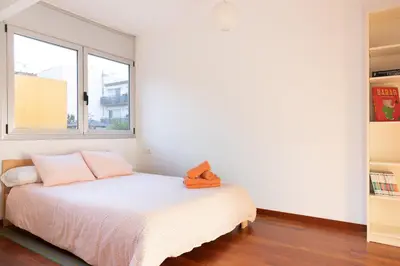 a white bedroom with a bed and a window at Lets Holidays Terrace Barcelona in Barcelona