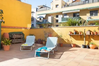 two chairs on a patio in front of a building at Lets Holidays Terrace Barcelona in Barcelona
