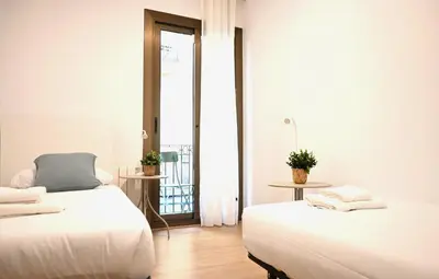 two beds in a room with a balcony at Homenfun Barcelona Avenida Diagonal in Barcelona