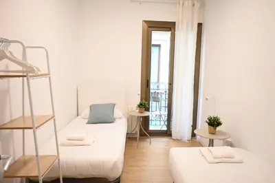 a white room with two beds and a window at Homenfun Barcelona Avenida Diagonal in Barcelona