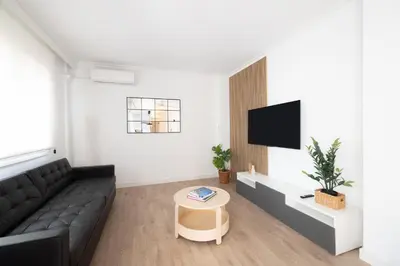 a living room with a black couch and a tv at Stay U-nique Apartments Villarroel II in Barcelona